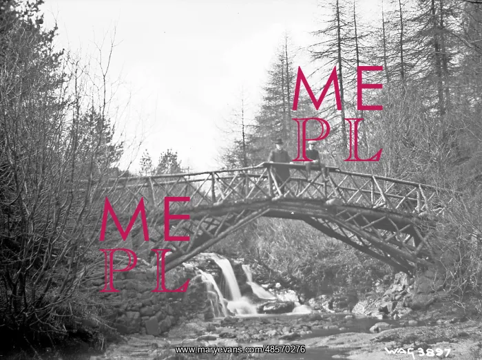 : A rustic wooden bridge over a river and two men on it (unsha : A rustic wooden bridge over a river and two men on it (unsha