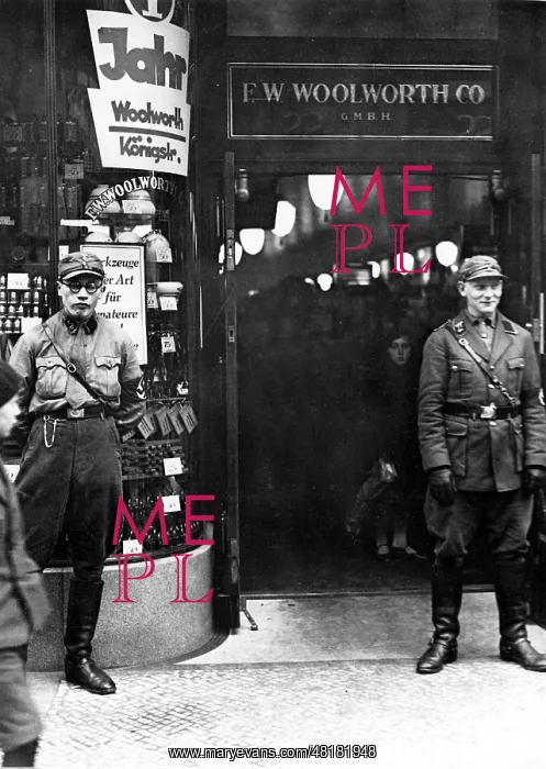 : SA men stand guard outside a branch of Woolworth : SA men stand guard outside a branch of Woolworth