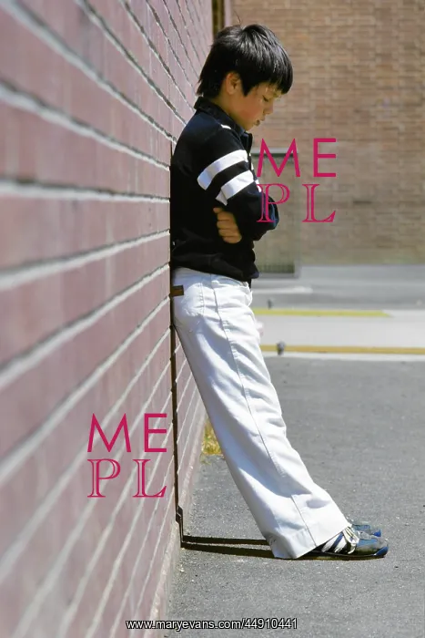 : Sad Boy Standing Against Brick Wall in School Playground : Sad Boy Standing Against Brick Wall in School Playground