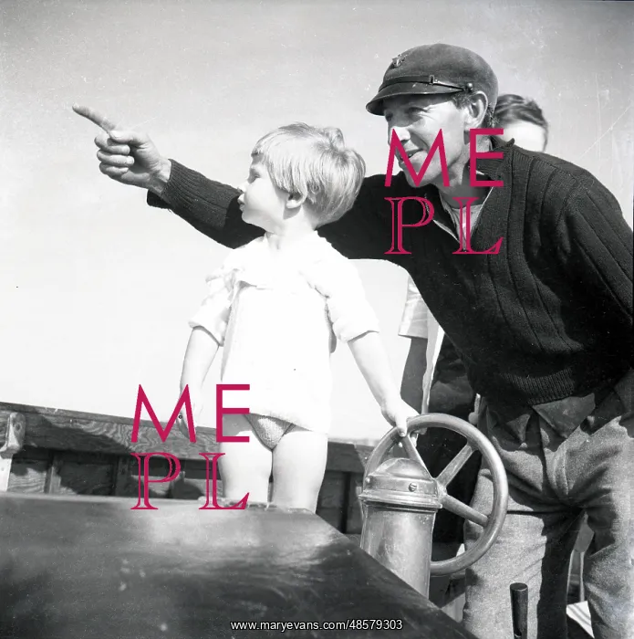 : Sailor and small child at the ship's wheel : Sailor and small child at the ship's wheel