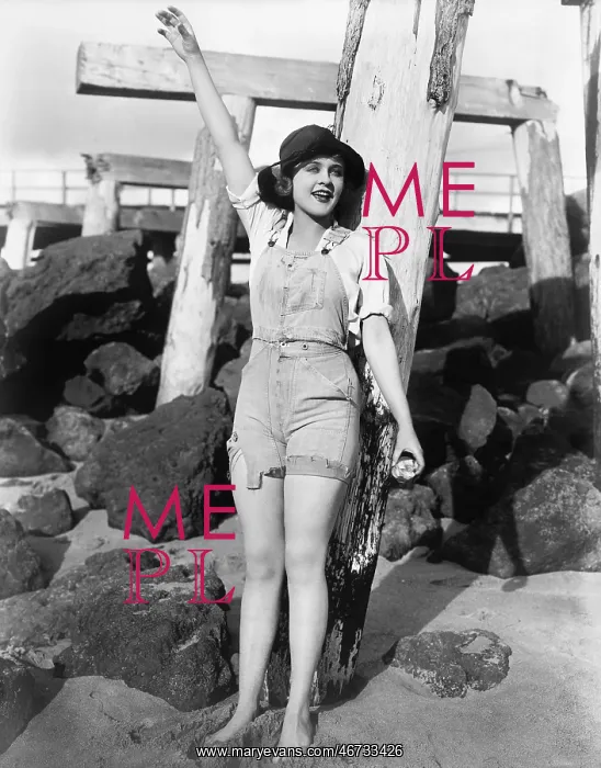 : With sand between her toes, a young woman waves : With sand between her toes, a young woman waves
