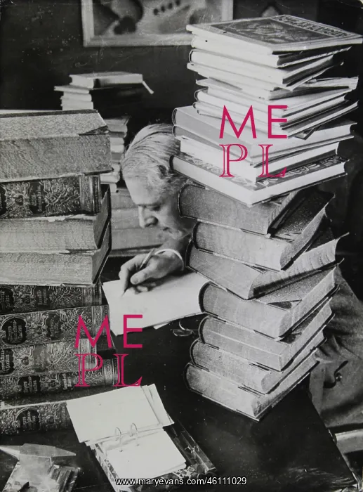 : A scientist sits surrounded by piles : A scientist sits surrounded by piles