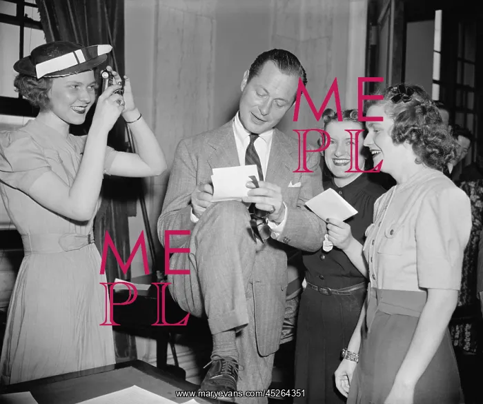 : Screen actor Robert Montgomery, autographing for : Screen actor Robert Montgomery, autographing for
