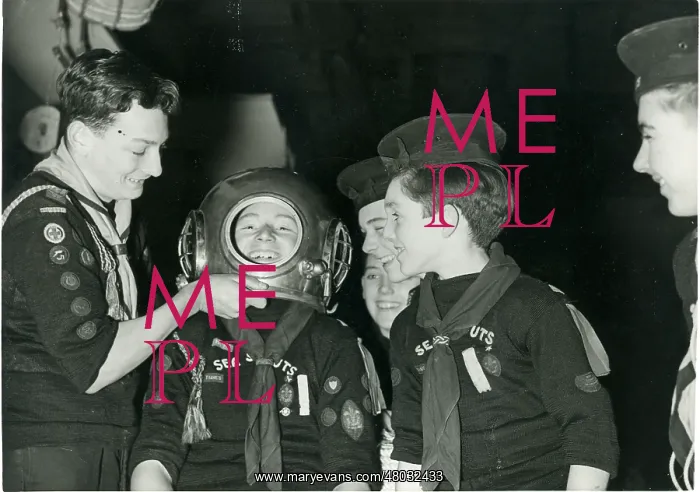 : Sea Scouts trying out a diver's helmet : Sea Scouts trying out a diver's helmet