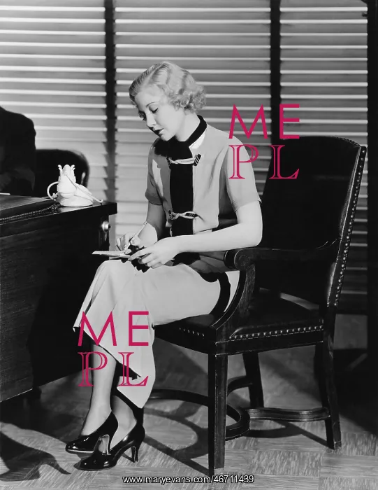 : Secretary at her office desk taking notes : Secretary at her office desk taking notes