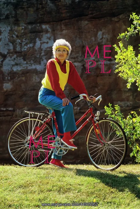 : Senior woman on bicycle standing still looking : Senior woman on bicycle standing still looking