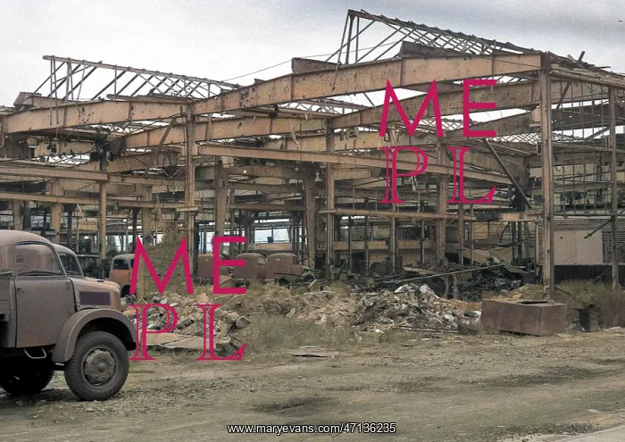 : Shell of a building with parked vehicles : Shell of a building with parked vehicles
