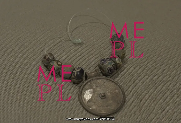 : Silver medallion and faience eye beads : Silver medallion and faience eye beads