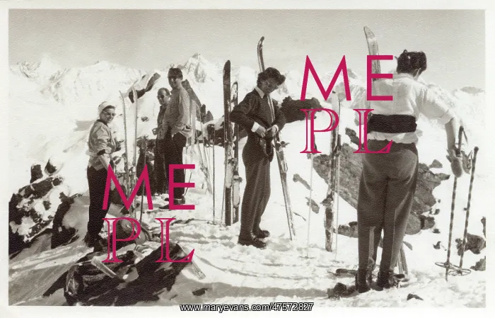  : Skiers on top of a show covered mountain