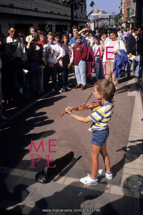 : Small boy busking with his violin for an audience in Dublin : Small boy busking with his violin for an audience in Dublin