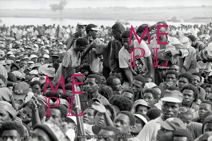 : A small group stand in the midst of a seated crowd : A small group stand in the midst of a seated crowd
