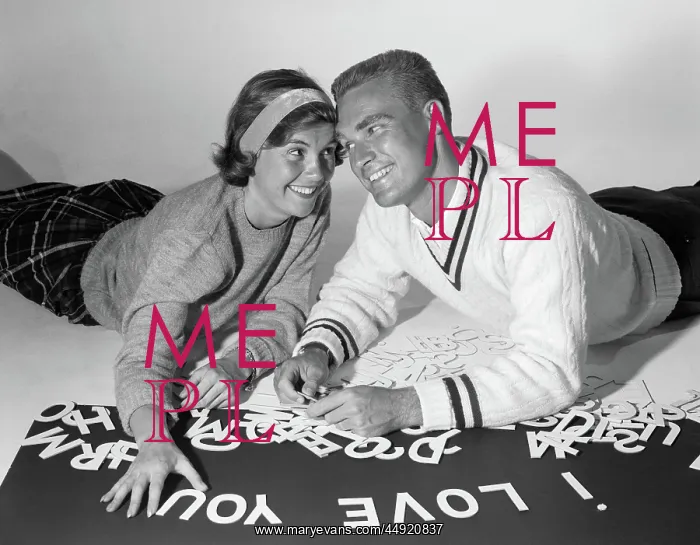 : Smiling collegiate couple lying on stomachs with : Smiling collegiate couple lying on stomachs with