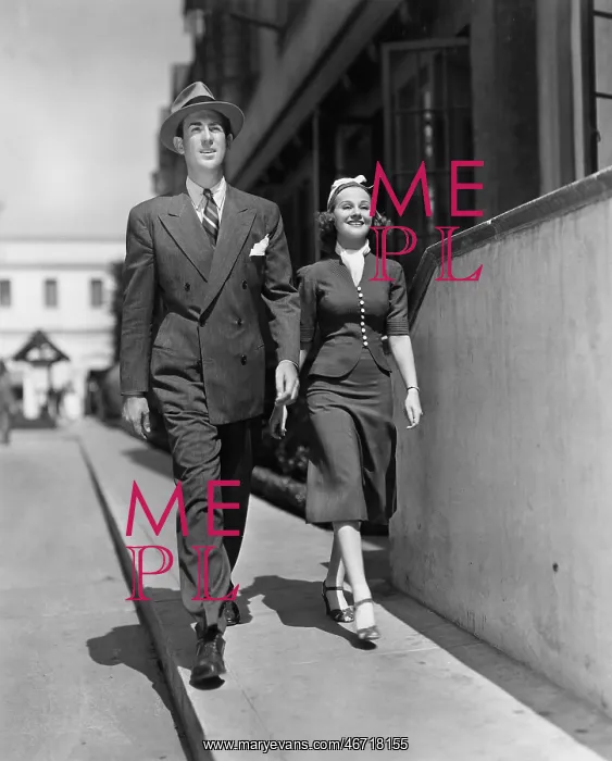 : Smiling couple walking on sidewalk : Smiling couple walking on sidewalk