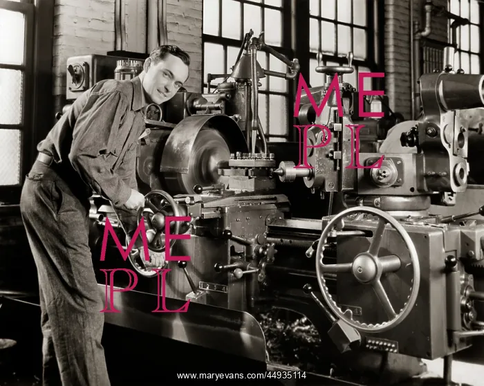 : Smiling Man Working a Lathe Machine in a Factory : Smiling Man Working a Lathe Machine in a Factory