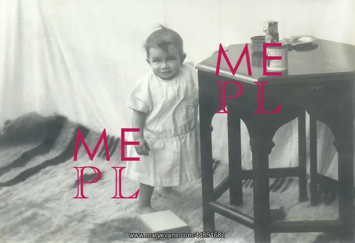 : Smiling toddler leaning against a table : Smiling toddler leaning against a table