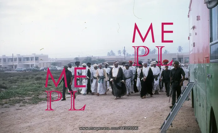 : Soldiers with Omani elders walking in the sand. in Oman : Soldiers with Omani elders walking in the sand. in Oman
