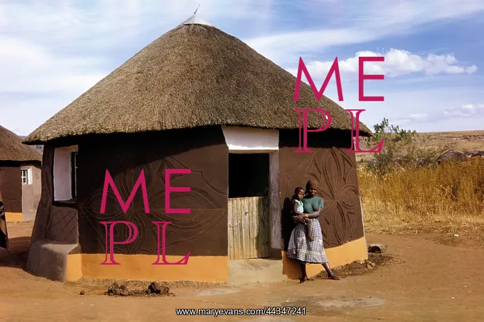 : Sotho woman standing outside a hut : Sotho woman standing outside a hut