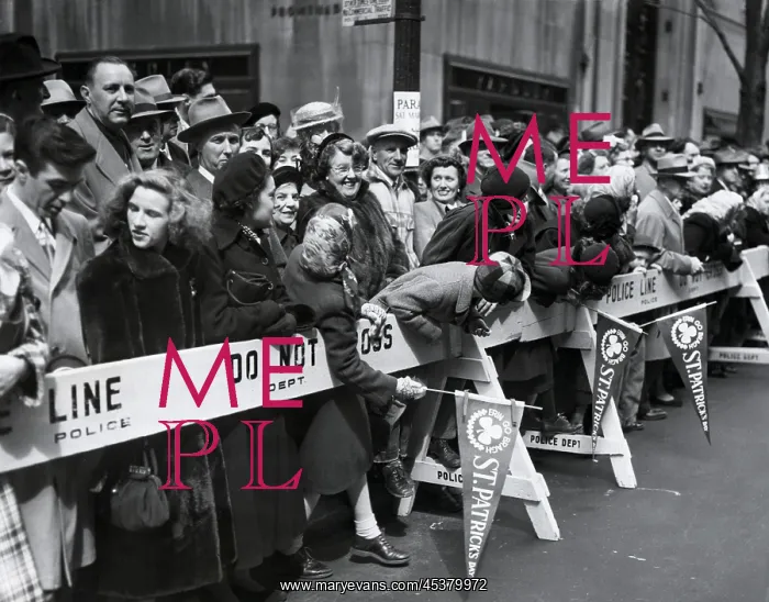 : Spectators lean over barricades to watch the : Spectators lean over barricades to watch the
