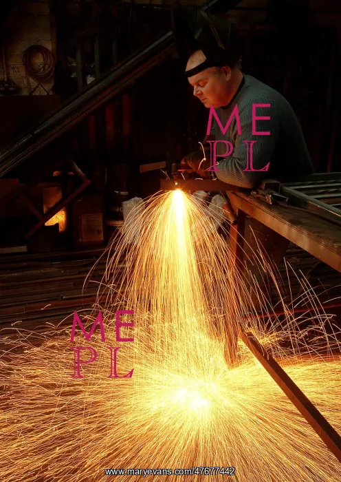 : A steelworker makes a shower of sparks in his workshop : A steelworker makes a shower of sparks in his workshop