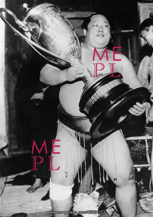 : A sumo wrestler with a trophy. Tokyo : A sumo wrestler with a trophy. Tokyo