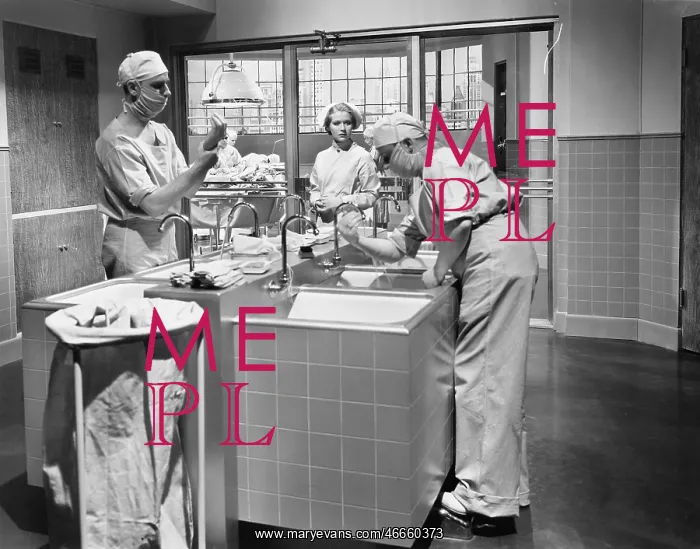 : Two surgeons and a nurse in the scrub room preparing : Two surgeons and a nurse in the scrub room preparing