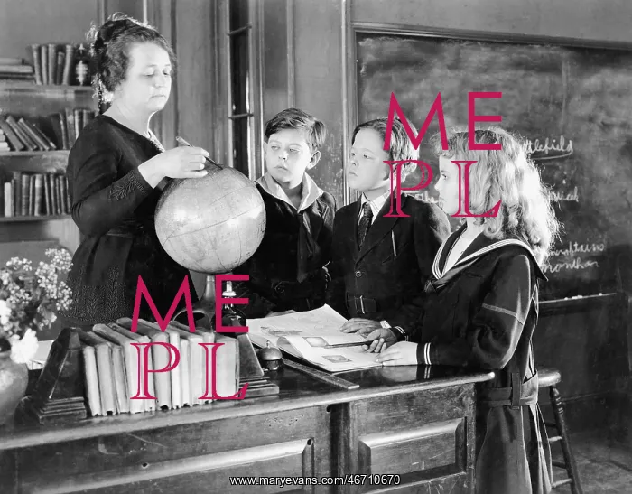 : Teacher in a classroom with three pupils pointing : Teacher in a classroom with three pupils pointing