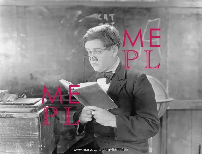 : Teacher holding a book in front of a black board : Teacher holding a book in front of a black board