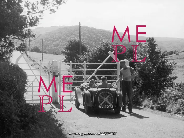 : TOLL GATE. A young couple in an open-top sports car pay their dues at the : TOLL GATE. A young couple in an open-top sports car pay their dues at the