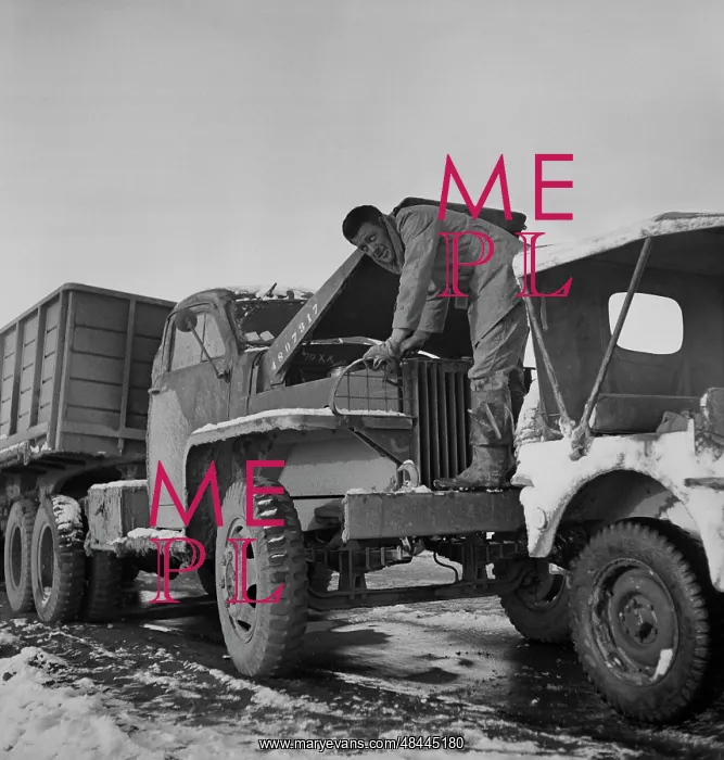 : A truck driver with the U.S. Army checking the oil : A truck driver with the U.S. Army checking the oil