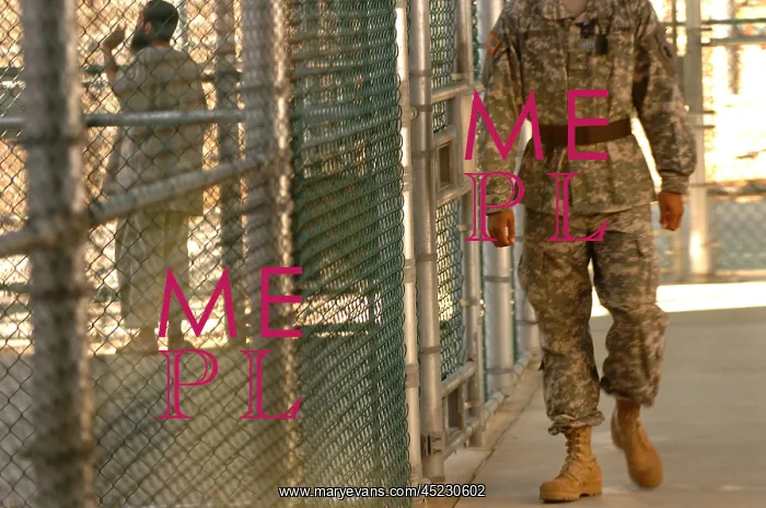 : A U.S. Army Soldier stands guard as a detainee ? : A U.S. Army Soldier stands guard as a detainee ?