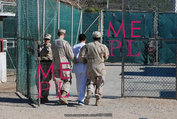 : U.S. Navy guards escort a detainee through ? : U.S. Navy guards escort a detainee through ?