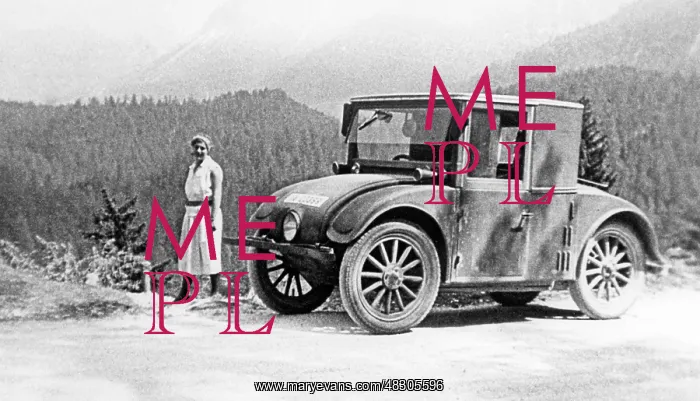 : Vacationer next to small car on a mountain road, around the : Vacationer next to small car on a mountain road, around the