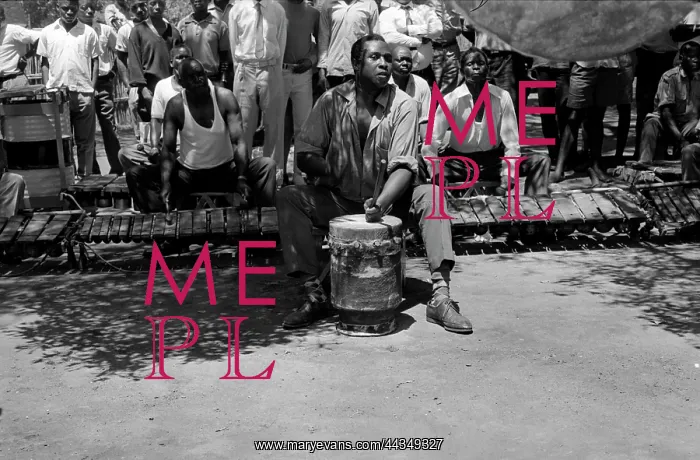: Venancio Mbande playing nzoma drum during entry movement : Venancio Mbande playing nzoma drum during entry movement