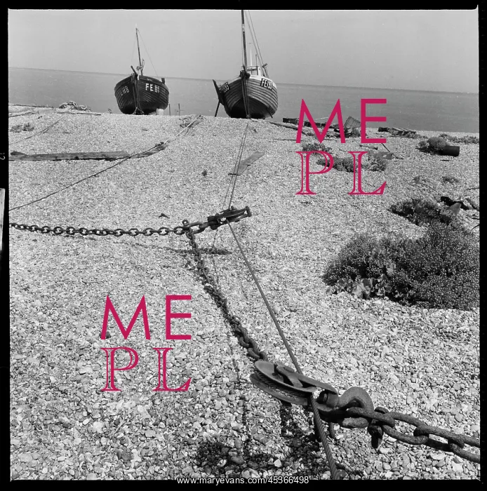 : A view along the beach towards a pair of fishing : A view along the beach towards a pair of fishing