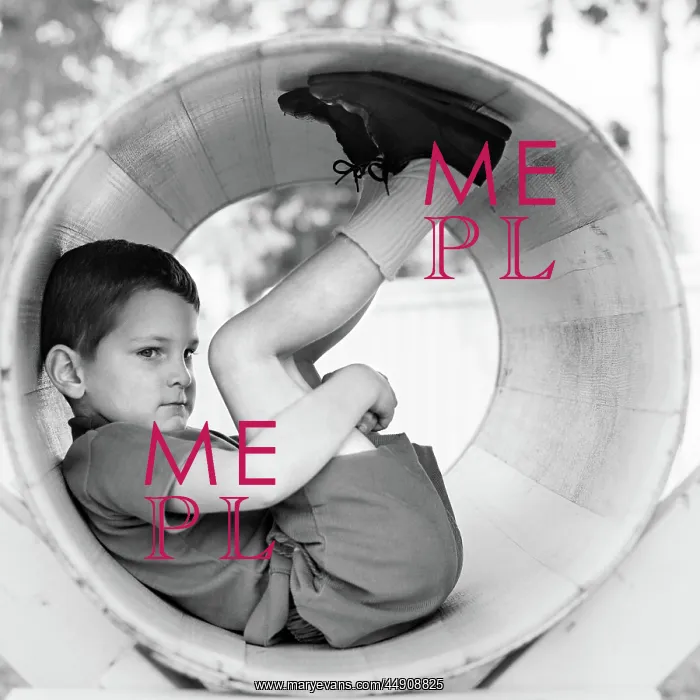 : Side view of boy scrunched up inside tube holding : Side view of boy scrunched up inside tube holding