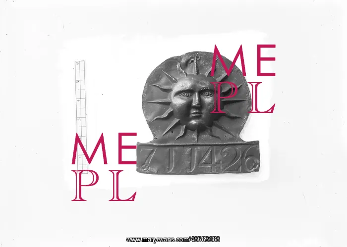 : A view of a sun face plaque on a white background : A view of a sun face plaque on a white background
