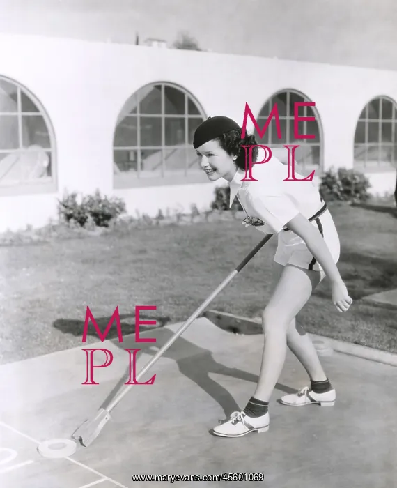 : Side view of woman playing shuffleboard : Side view of woman playing shuffleboard