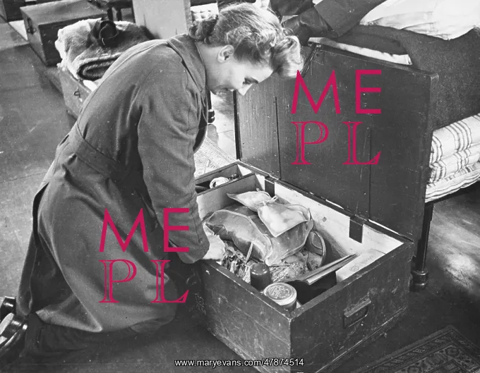  : WAAF WWII. A WAAF inspects her locker at the end of her bed, which holds her tuck