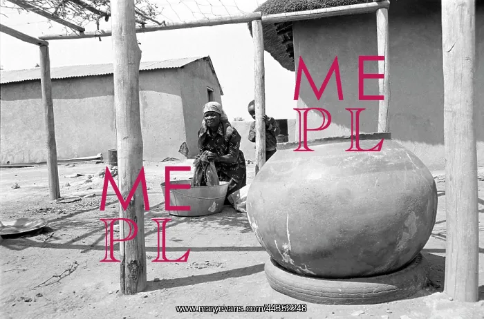 : Washing clothes in a courtyard with large clay pot : Washing clothes in a courtyard with large clay pot