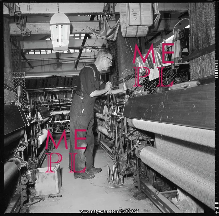 : A weaver operating a Jacquard power loom : A weaver operating a Jacquard power loom