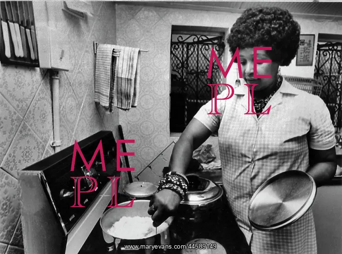 : Winnie Mandela preparing a meal in the kitchen : Winnie Mandela preparing a meal in the kitchen