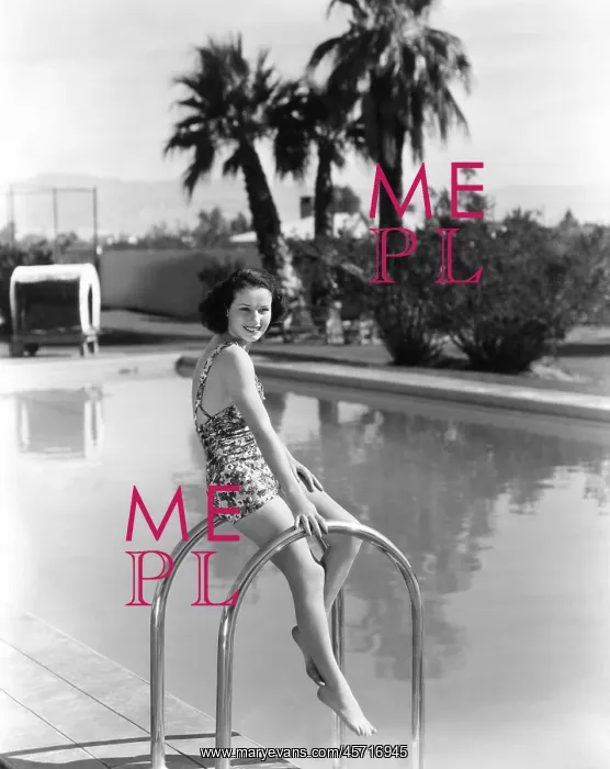  : Woman balancing on railing at swimming pool
