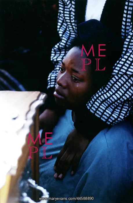 : A woman is comforted while weeping alongside a : A woman is comforted while weeping alongside a