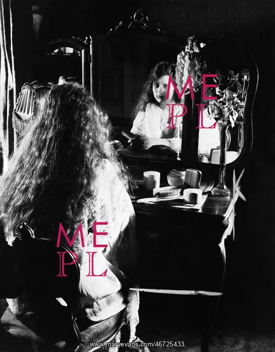 : Woman at dressing table looking in mirror : Woman at dressing table looking in mirror