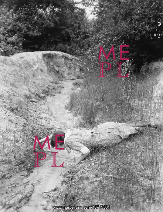  : Woman drinking from tiny stream