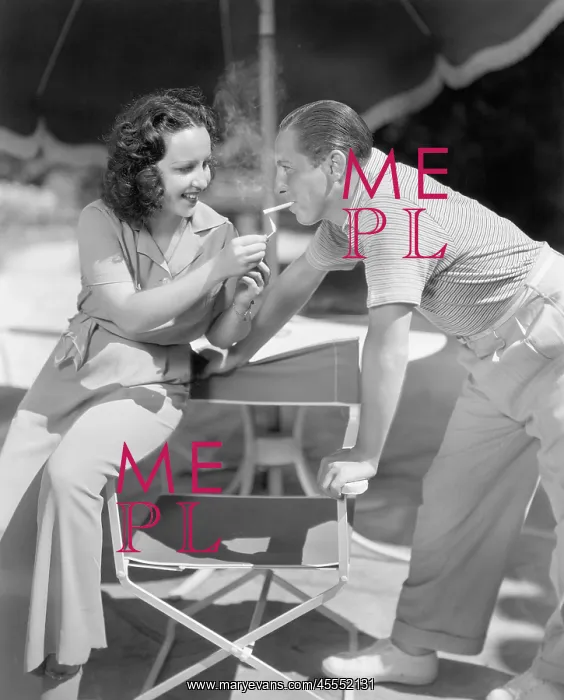 : Woman giving a man a light for his cigarette : Woman giving a man a light for his cigarette