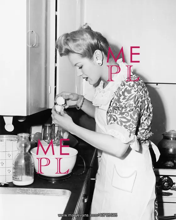 : Woman in the kitchen cracking an egg : Woman in the kitchen cracking an egg