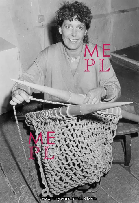 : Woman knitting with six foot needles : Woman knitting with six foot needles