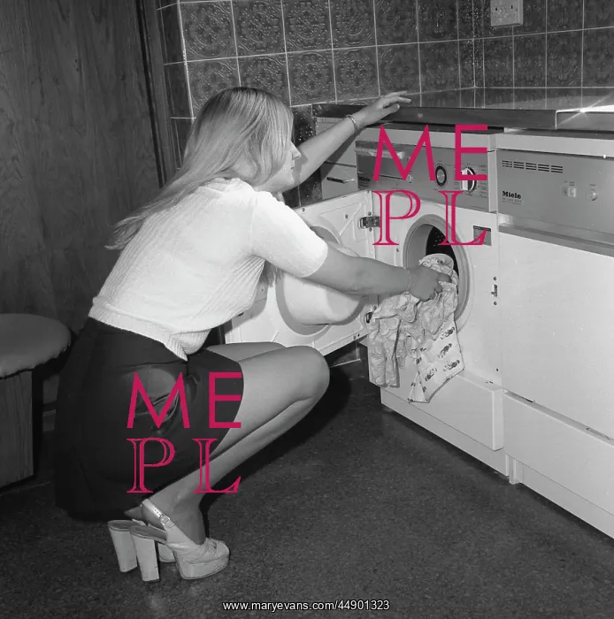 : Woman loading a washing machine : Woman loading a washing machine