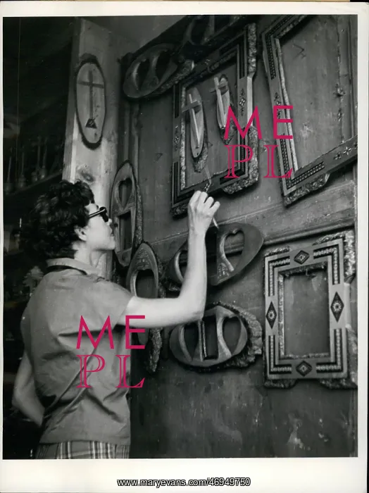 : Woman looking at display of frames and crosses : Woman looking at display of frames and crosses